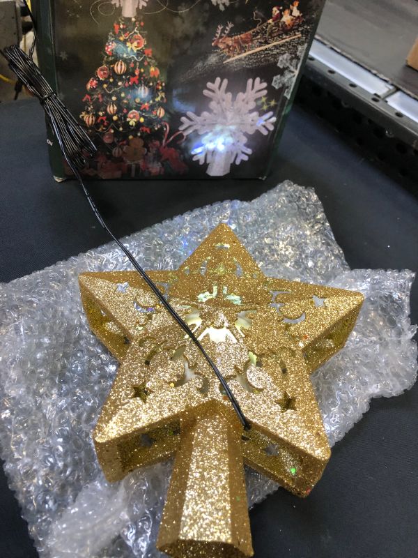Photo 2 of Christmas Star Tree Topper with LED Projector, Lighted Tree Topper with Rotating Warm Star Shape Lights, 3D Hollow Gold Star Xmas Tree Topper for Christmas Tree Decorations