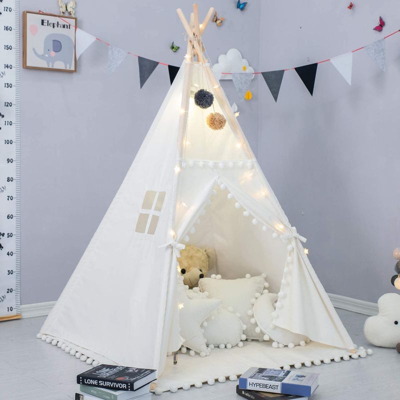 Photo 1 of LGMOONYE Foldable Teepee Tent for Kids Lace Pompom Ball Design with Floor Mat, Carry Case, Banner, Four Ploes Classic Cute Children Playing House Indoor Outdoor Nursery Decor
