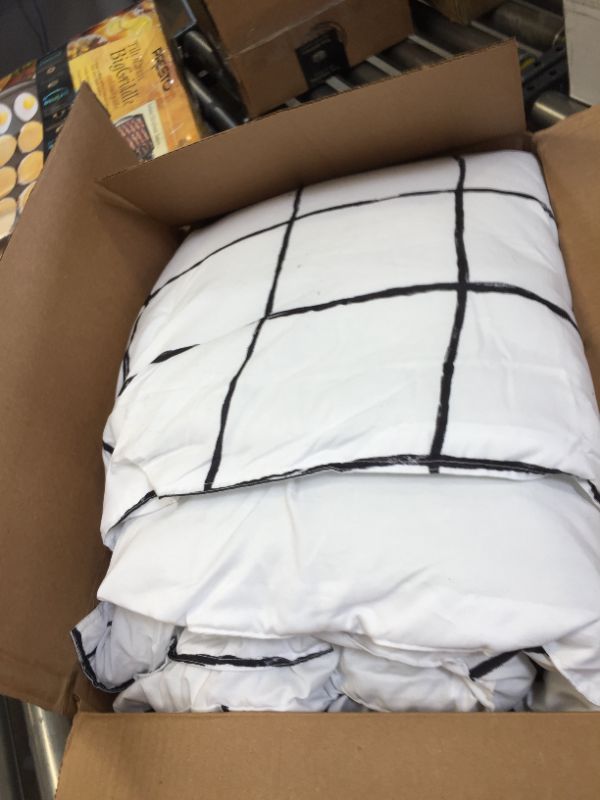 Photo 1 of 66X86INCH WHITE AND BLACK PATTERN BLANKET. DIRT STAINS AND HAIR FOUND ON ITEM. 