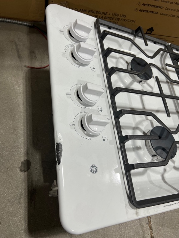 Photo 5 of GE® 30" Built-In Gas Cooktop with Dishwasher-Safe Grates, Model #:JGP3030DLWW (OUT OF BOX, ITEM HAS A SCRATCH ON THE RIGHT TOP SURFACE, THERE ARE SCRATCHES ON THE GRILLS)
