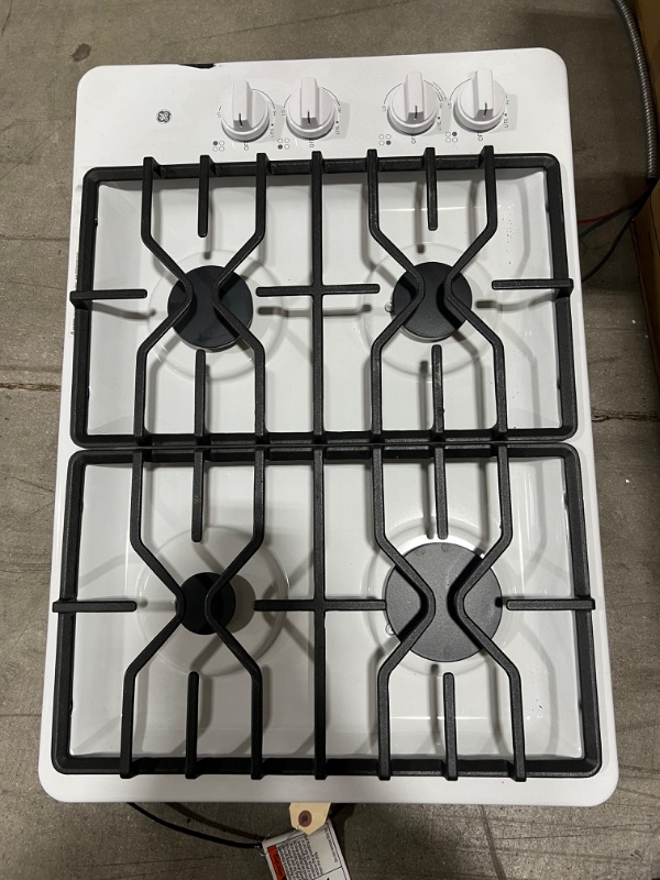 Photo 2 of GE® 30" Built-In Gas Cooktop with Dishwasher-Safe Grates, Model #:JGP3030DLWW (OUT OF BOX, ITEM HAS A SCRATCH ON THE RIGHT TOP SURFACE, THERE ARE SCRATCHES ON THE GRILLS)
