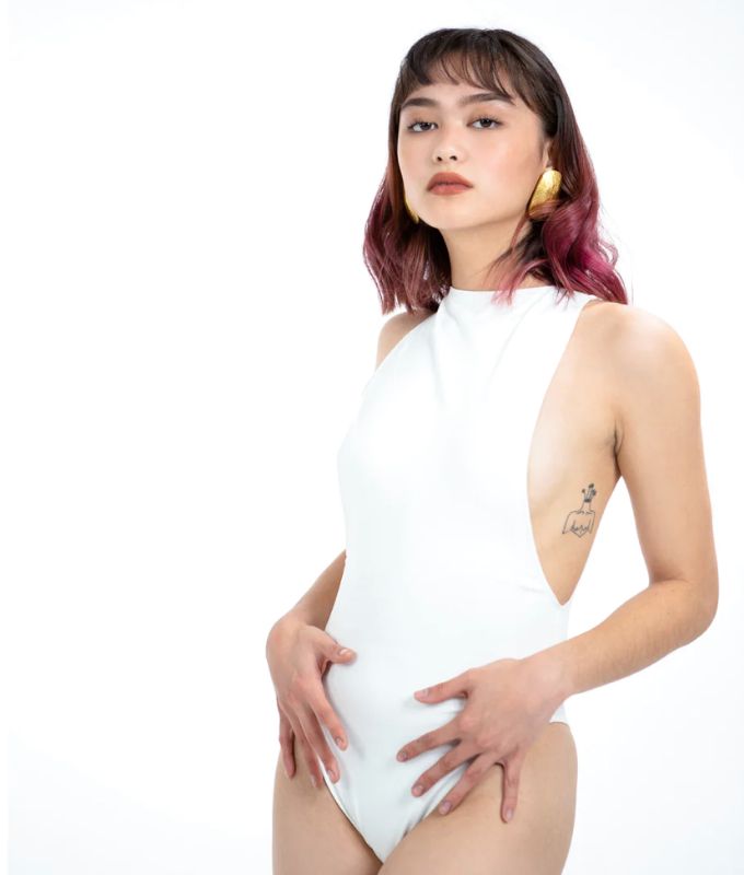 Photo 2 of SIZE LARGE WHITE EUNICE BODYSUIT FEATURES A BOAT NECK LINE WITH HIGH COURT LEGS AND A LOW CUT ON SIDES THAT GIVE YOU AM EDGY LOOK.