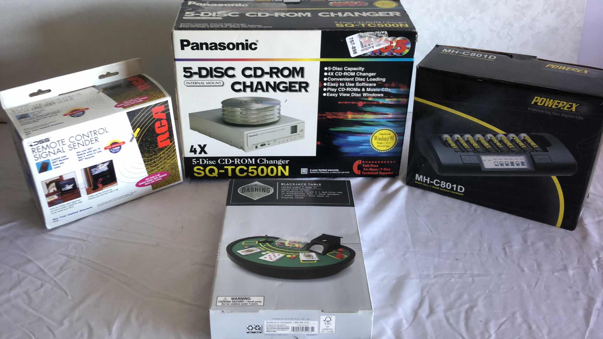 Photo 1 of ASSORTED ELECTRONICS PANASONIC CD CHANGER, BATTERY CHARGER, REMOTE SIGNAL SENDER, MINI BLACKJACK TABLE NEW IN BOX