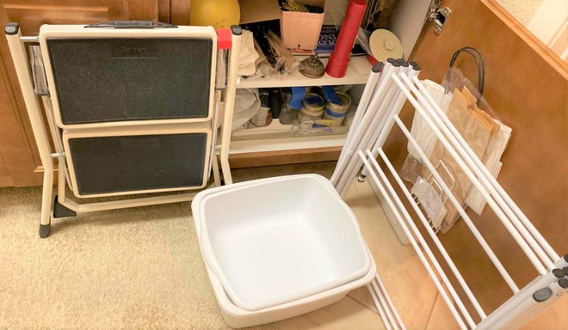Photo 1 of CONTENTS OF CABINET LAUNDRY ROOM CABINET AND CLOTHES DRYING RACK STEP STOOL AND PLASTIC CONTAINERS