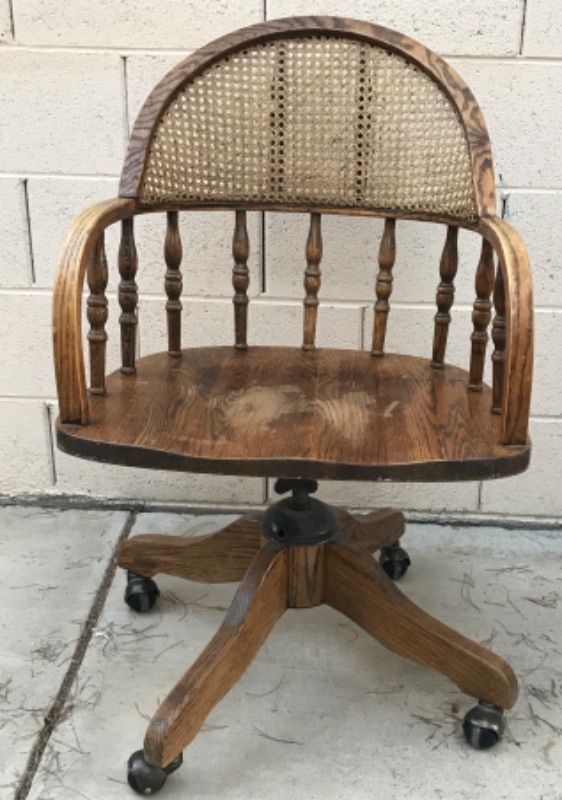 Photo 1 of ANTIQUE SOLID WOOD SWIVEL CHAIR WITH CURVED CANE BACK ON CASTERS