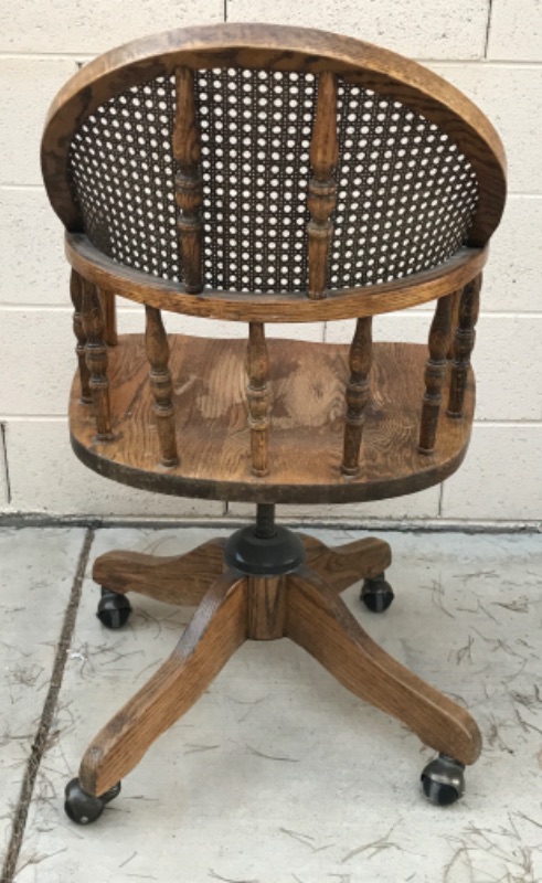 Photo 2 of ANTIQUE SOLID WOOD SWIVEL CHAIR WITH CURVED CANE BACK ON CASTERS