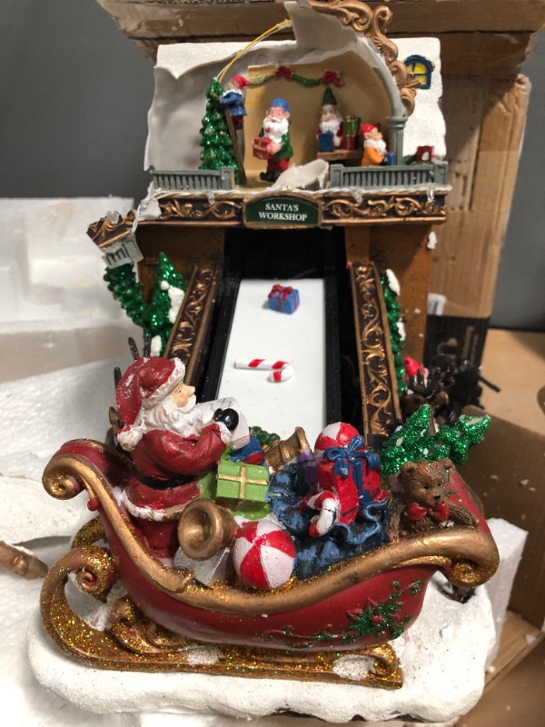 Photo 3 of **UNIT DAMAGED** Moments In Time Christmas Village Building, Santa's Toy Shop Conveyer Belt Loading his Sleigh with Christmas Music, LED Lights, and Animation - Power Adapter (Included) (10.4" H x 7.2" W x 10.6" D)
