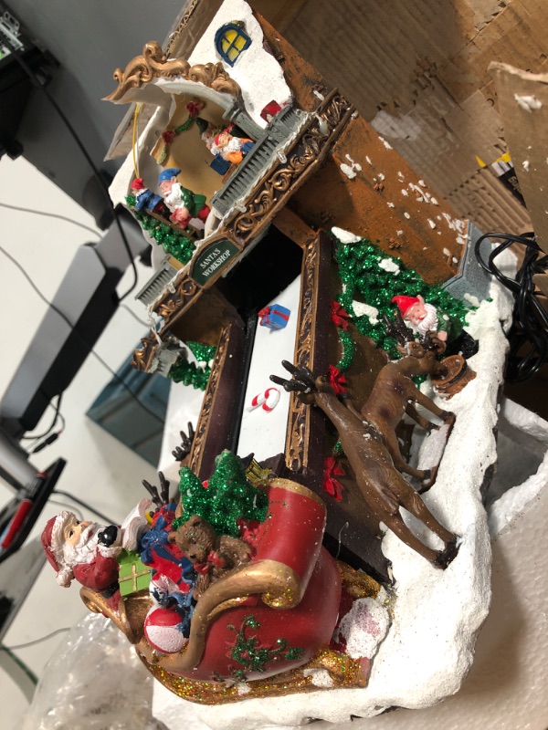 Photo 2 of **UNIT DAMAGED** Moments In Time Christmas Village Building, Santa's Toy Shop Conveyer Belt Loading his Sleigh with Christmas Music, LED Lights, and Animation - Power Adapter (Included) (10.4" H x 7.2" W x 10.6" D)
