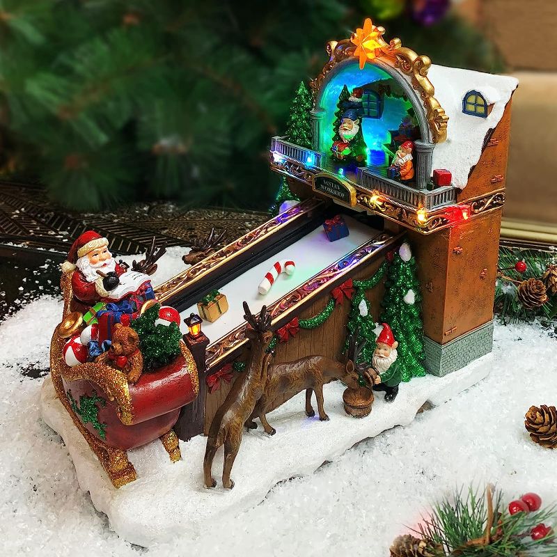 Photo 1 of **UNIT DAMAGED** Moments In Time Christmas Village Building, Santa's Toy Shop Conveyer Belt Loading his Sleigh with Christmas Music, LED Lights, and Animation - Power Adapter (Included) (10.4" H x 7.2" W x 10.6" D)
