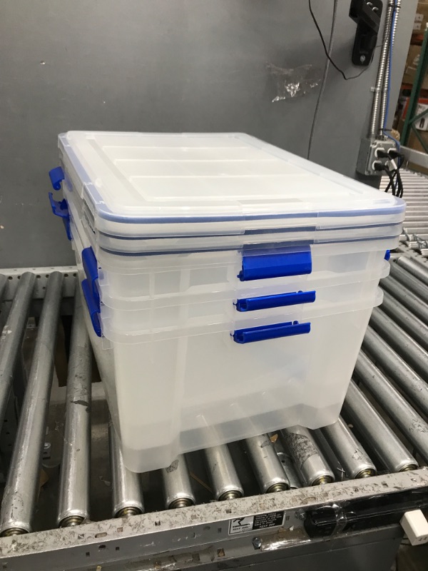 Photo 2 of ****MINOR DAMAGE**  IRIS USA 60 Quart WEATHERPRO Plastic Storage Box with Durable Lid and Seal and Secure Latching Buckles, Clear With Blue Buckles, Weathertight, 3 Pack 60 Quart - 3 Pack