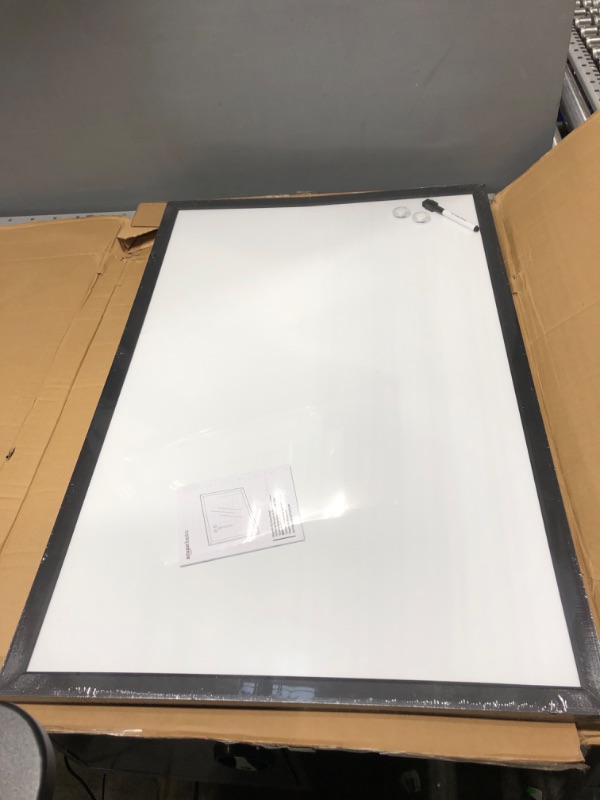 Photo 2 of ***Back of dry erase board has a few cracks in cardboard** does not effect useage of dry erase board 
Amazon Basics Magnetic Dry Erase White Board, 35 x 23-Inch Whiteboard - Black Wooden Frame 23"x35" Magnetic, Wood Frame