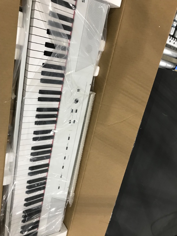 Photo 2 of Alesis Recital – 88 Key Digital Piano Keyboard with Semi Weighted Keys, 5 Voices, Piano Lessons, M-Audio Sustain Pedal and HDH40 Piano Headphones Recital White Piano + Sustain Pedal + Headphones