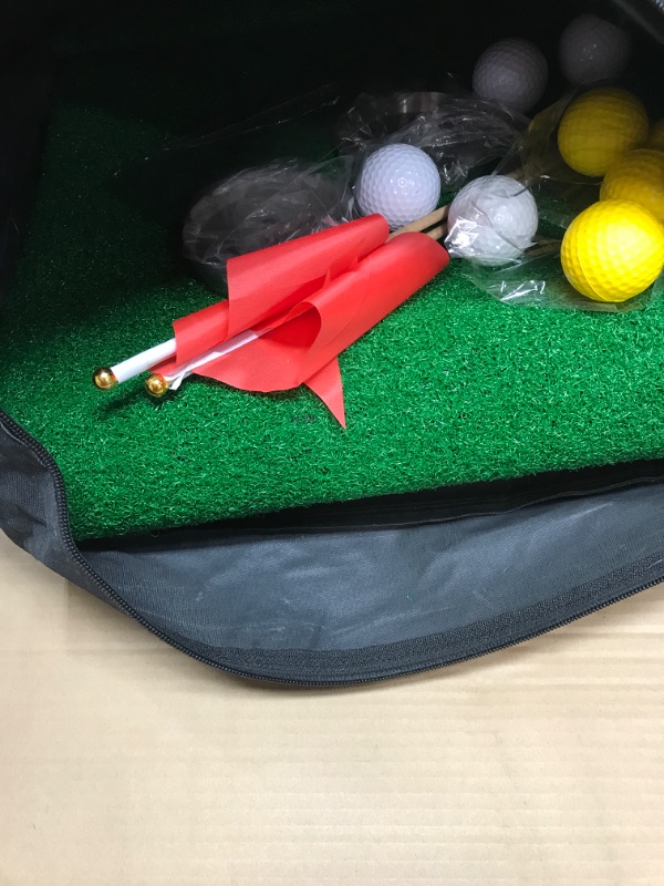 Photo 2 of  Golf Putting Mat –  Artificial Grass Texture Putting Green – with two tun holes  two red flags four white balls four yellow balls and a black carrying bag 
