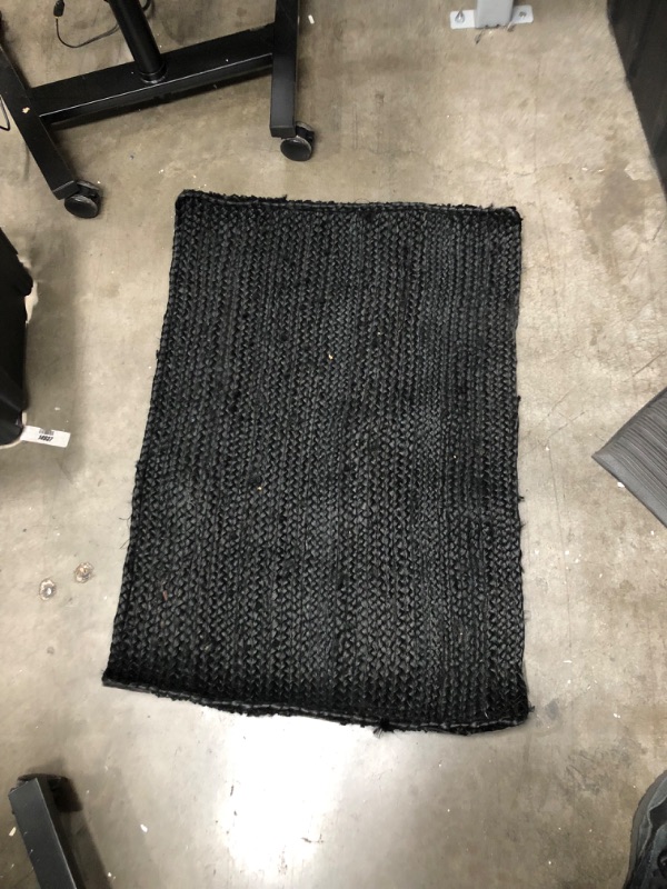 Photo 1 of **used, needs cleaning**
24 inch x 35 inch black natrual rug