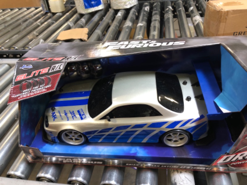 Photo 2 of Jada Toys Fast & Furious Brian's Nissan Skyline GT-R (BN34) Drift Power Slide RC Radio Remote Control Toy Race Car with Extra Tires, 1:10 Scale, Silver/Blue (99701)
