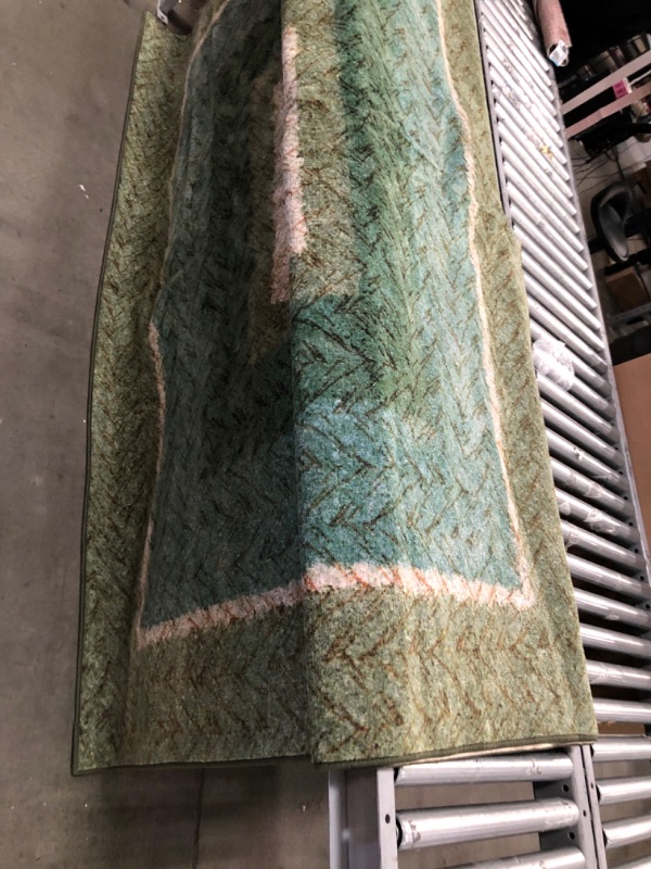 Photo 1 of **USED, NEEDS CLEANING**
7'9"FT X 14 FT GREEN, TEAL & TAN RUG