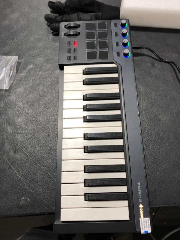 Photo 2 of Donner STARRYKEY MIDI Keyboard MIDI Controller, Full Size 25 keys, 7 Colors Lighting Effect, 8 Velocity-sensitive Backlit Pads with 24 Selectable Custom Tones, with MIDI out and Pedal interface
