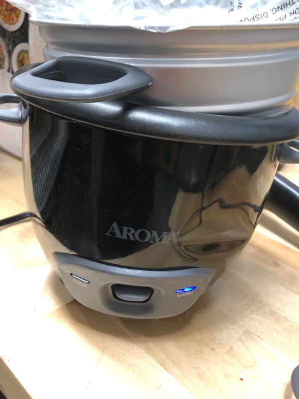 Photo 2 of **POT HAS SMALL DENTS**
Aroma Housewares 6-Cup (Cooked) Pot-Style Rice Cooker and Food Steamer, Black ARC-743-1NGB