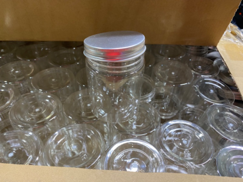 Photo 1 of 6OZ PLASTIC MASON JARS WITH LIDS AMOUNT UNKNOWN ATLEASE 50