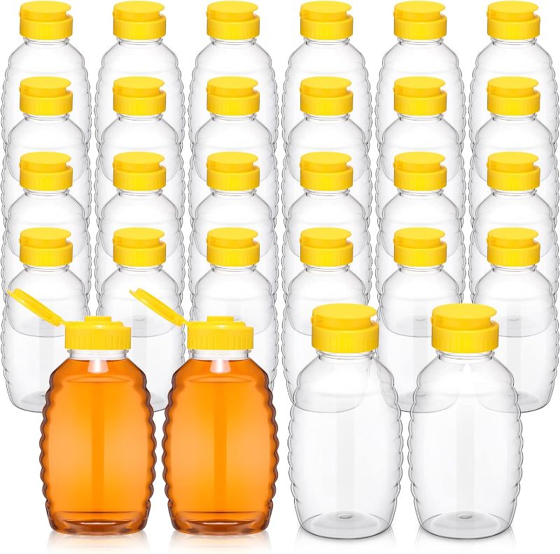 Photo 1 of 24 Pcs Clear Plastic Honey Bottles Plastic Skep Style Jar Honey Squeeze Bottle Empty Refillable Honey Dispenser with Flip Top Lids Leak Proof Honey Containers Holders for Storing and Dispensing (12oz)
