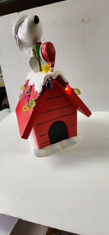 Photo 5 of 19" Peanuts Snoopy & Woodstock Holiday Dog House. For Indoor Decorative Use Only. The beloved Peanuts characters, Snoopy & Woodstock, have become synonymous with the Holidays since their debut over 70 years ago. Bring the magic of these cherished characte