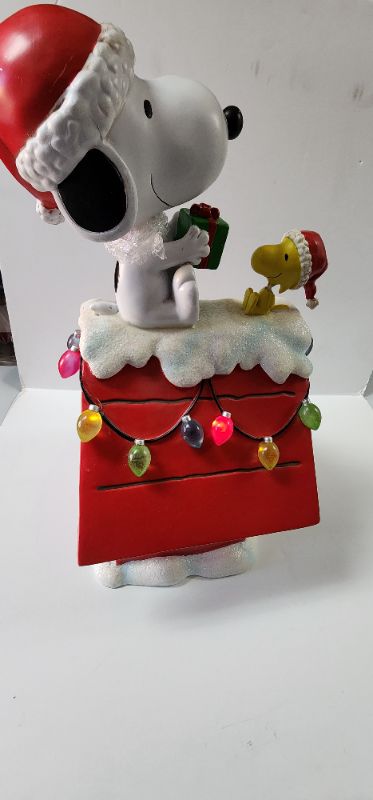 Photo 6 of 19" Peanuts Snoopy & Woodstock Holiday Dog House. For Indoor Decorative Use Only. The beloved Peanuts characters, Snoopy & Woodstock, have become synonymous with the Holidays since their debut over 70 years ago. Bring the magic of these cherished characte
