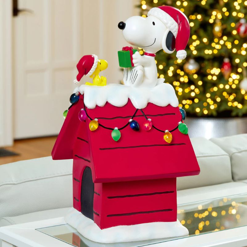 Photo 1 of 19" Peanuts Snoopy & Woodstock Holiday Dog House. For Indoor Decorative Use Only. The beloved Peanuts characters, Snoopy & Woodstock, have become synonymous with the Holidays since their debut over 70 years ago. Bring the magic of these cherished characte