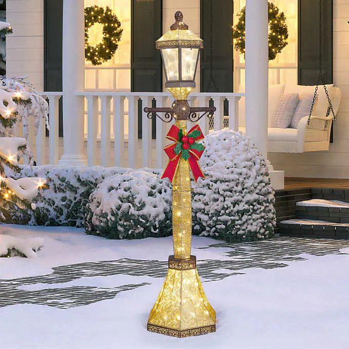 Photo 1 of This beautiful lamp post shines and sparkles with 120 Warm LED lights from Costco, wrapped with glittery gold weather resistant fabric and bronze metal trims. A large festive bow with holly leaves creates the perfect accent. Easy to integrate into any Hol