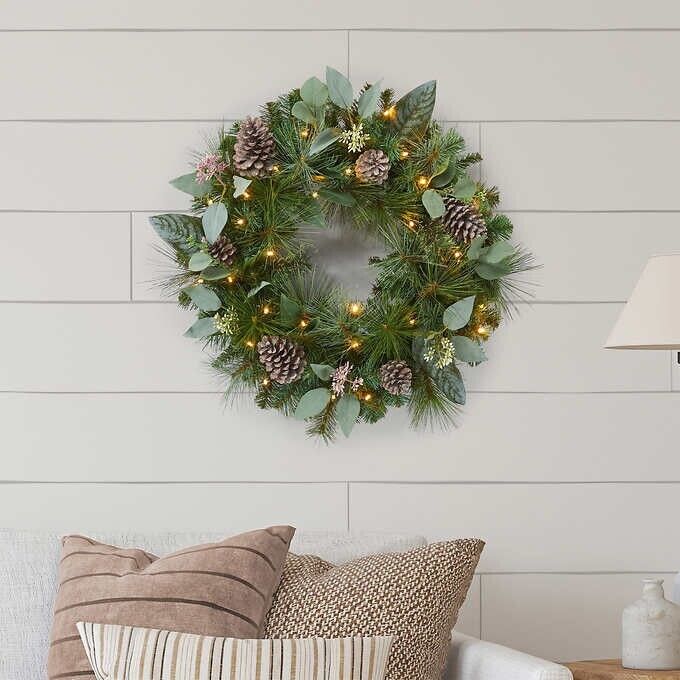 Photo 2 of 24" Pre-Lit Artificial Mixed Greenery Wreath. Make your entrance merry with this lush, beautiful holiday wreath. Resembling a fresh mix of Scotch pine, magnolia, and pear leaves, all accented with white-washed pinecones and faux eucalyptus. This wreath ha