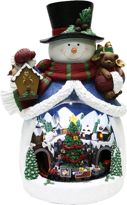 Photo 1 of Moments In Time Christmas Decor Snowman with Christmas Village Scene, with LED Lights, Christmas Music, and Animation - Power Adapter (Included) (18.7" H x 11.4" W x 12.8" D). Plays 8 Classic Christmas Songs: We Wish You A Merry Christmas; O Christmas Tre