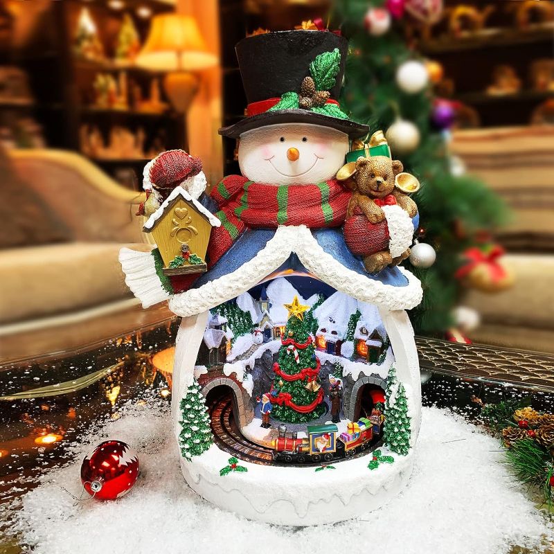 Photo 8 of Moments In Time Christmas Decor Snowman with Christmas Village Scene, with LED Lights, Christmas Music, and Animation - Power Adapter (Included) (18.7" H x 11.4" W x 12.8" D). Plays 8 Classic Christmas Songs: We Wish You A Merry Christmas; O Christmas Tre