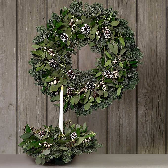 Photo 1 of Eucalyptus Wreath This Wreath features a blue toned noble fir base with accent greens of green Bay Leaf and Seeded Eucalyptus. This upscale look is completed by the addition of white painted Lodgepole pine cones and faux white tallow berries. Bring the sc