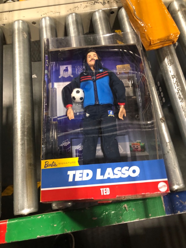 Photo 1 of Barbie Signature Doll, Ted Lasso Wearing Iconic Blue AFC Richmond Tracksuit with Aviators, Collectible with Displayable Packaging