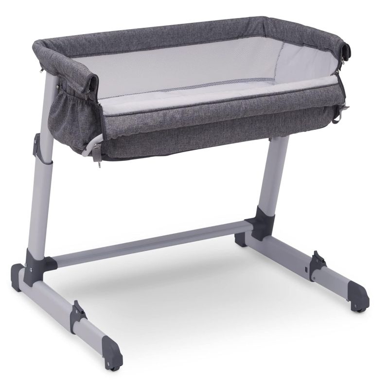 Photo 1 of Delta Children Simmons Kids Dream Bedside Bassinet with Zip-Down Side Wall – Convenient Baby Sleeper with Breathable Mesh and Adjustable Heights - Lightweight Portable Crib, Grey
