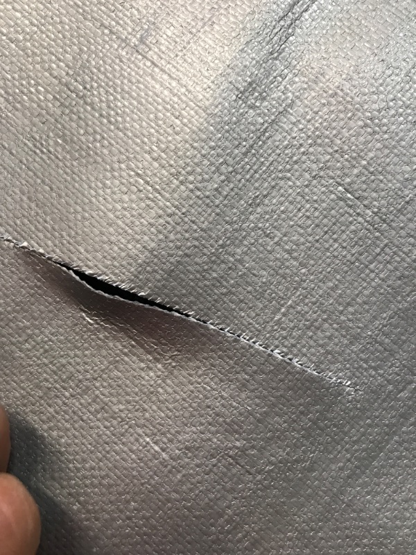 Photo 1 of TORN TARP**Core Tarps Heavy Duty 10 Mil Tarp Cover, Waterproof, UV Resistant, Rip and Tear Proof, Poly Tarpaulin with Reinforced Edges for Roof, Camping, Patio, Pool , Boat (Silver/Black 10? X 20?) Silver/Black-10 Mil 10? X 20?