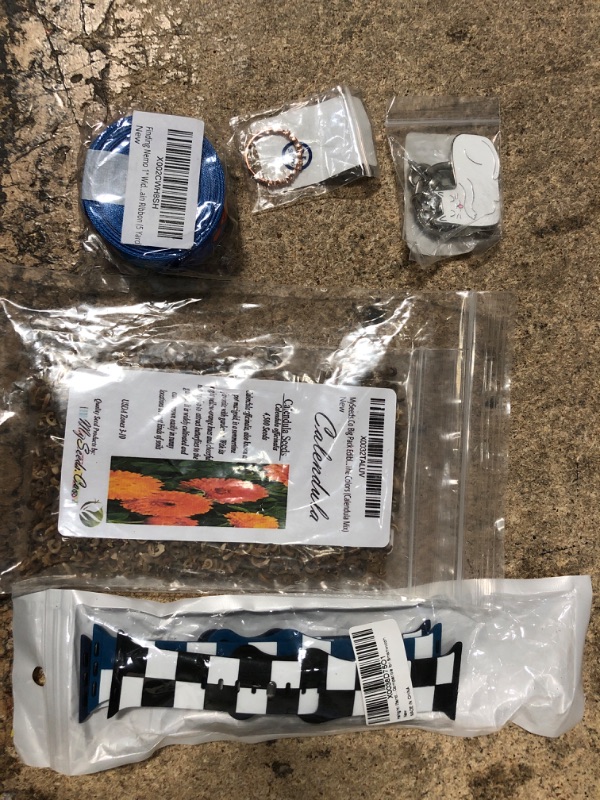 Photo 1 of 10 assorted items, apple wristbands, calendula seeds, xiomer twist ring, kitten keychain, finding nemo ribbon, dent puller kit, 12v power adapter, and misc.