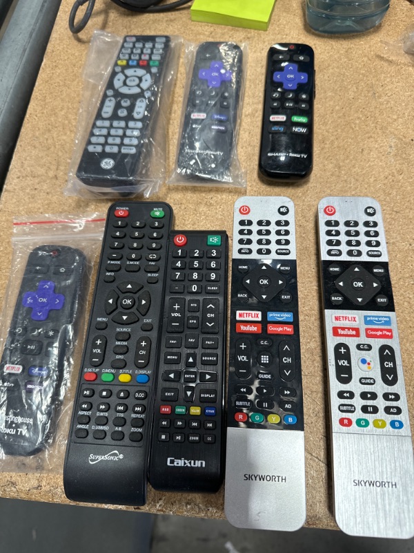 Photo 1 of Bundle of assorted remotes, 8 remotes total. 2 Skyworth, 1 Westinghouse Roku TV, 1 GE, 1 Sharp Roku TV, 1 Hisense Roku TV, 1 Caixun and 1 Supersonic