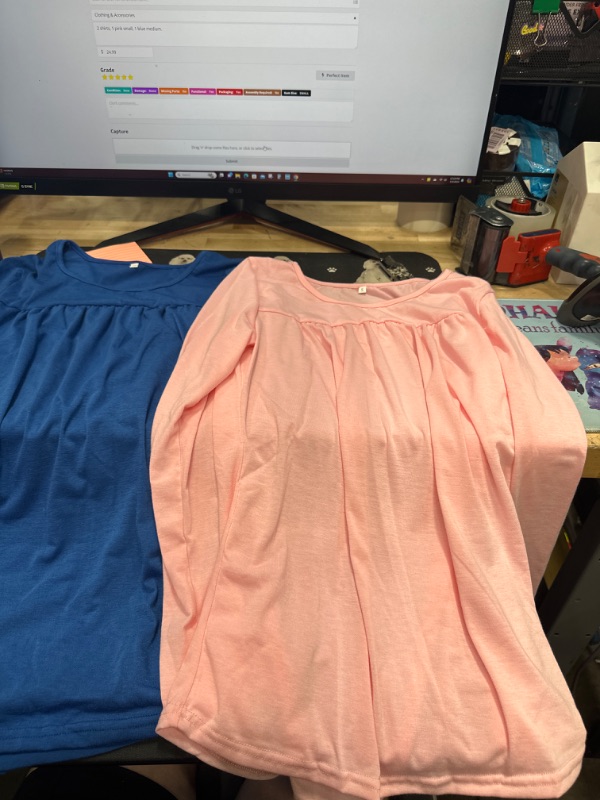 Photo 1 of 2 shirts, 1 pink small, 1 blue medium.