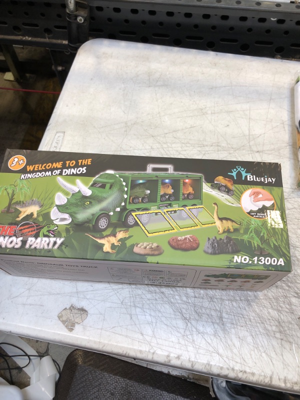 Photo 2 of BLUEJAY 21 Pack Dinosaur Toys for Kids 3-7, Dinosaur Truck with Oversized Dinosaur Map, Flashing Lights, Music and Roaring Sound, Kids Toys with 6 Pull Back Dinosaur Cars, 6 Dinosaur Toys (Green)