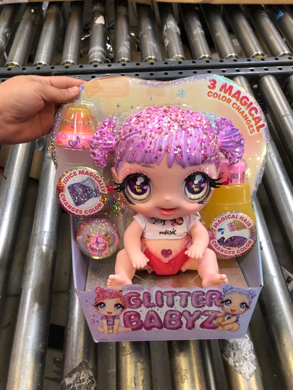 Photo 2 of MGA Entertainment Glitter Babyz Melody Highnote Baby Doll with 3 Magical Color Changes, Lavender Glitter Hair, Music Outfit, Diaper, Bottle, Pacifier Accessories, Ages 3 4 5+