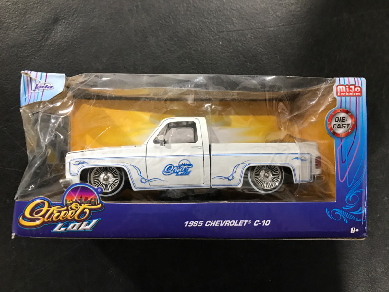 Photo 2 of Jada Toys 1985 Chevy C10 Pickup Truck Lowrider White Metallic with Blue Graphics Street Low Series 1/24 Diecast Model Car by Jada 34313