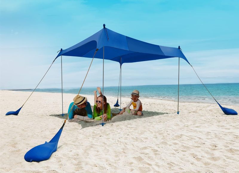 Photo 1 of Beach Canopy Tent Sun Shade - Rihogar Beach Tent Sun Shelter Upf50+, 10×10 FT, 4 Stability Aluminum Poles with Reinforced Anchoring Base for Beach, Camping, Backyard and Picnics, Royal Blue, Upgraded