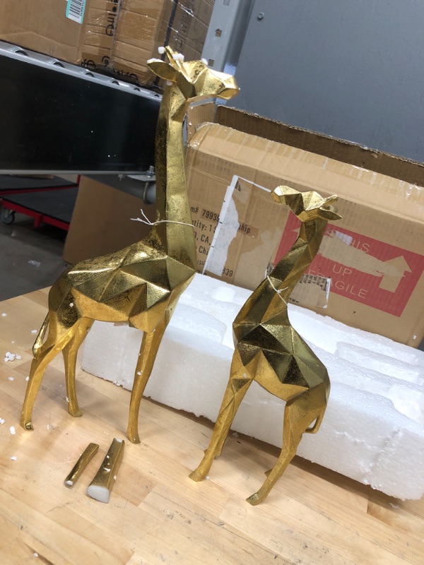 Photo 2 of **ONE LEG BROKIEN**
CosmoLiving by Cosmopolitan Modern Polystone Giraffe Sculpture, Set of 2 12", 15"H, Gold