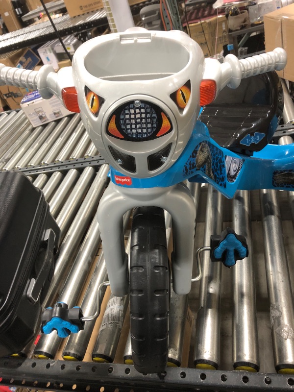 Photo 1 of Fisher-Price Jurassic World Velociraptor Dinosaur Tricycle, Toddler Toy Ride-On with Lights Sounds Walkie-Talkie and Storage Area