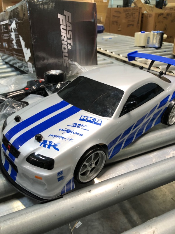 Photo 1 of Jada Toys Fast & Furious Brian's Nissan Skyline GT-R (BN34) Drift Power Slide RC Radio Remote Control Toy Race Car with Extra Tires, 1:10 Scale, Silver/Blue (99701)