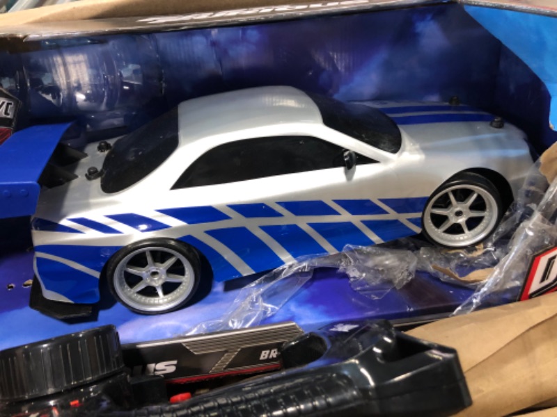 Photo 3 of Jada Toys Fast & Furious Brian's Nissan Skyline GT-R (BN34) Drift Power Slide RC Radio Remote Control Toy Race Car with Extra Tires, 1:10 Scale, Silver/Blue (99701)