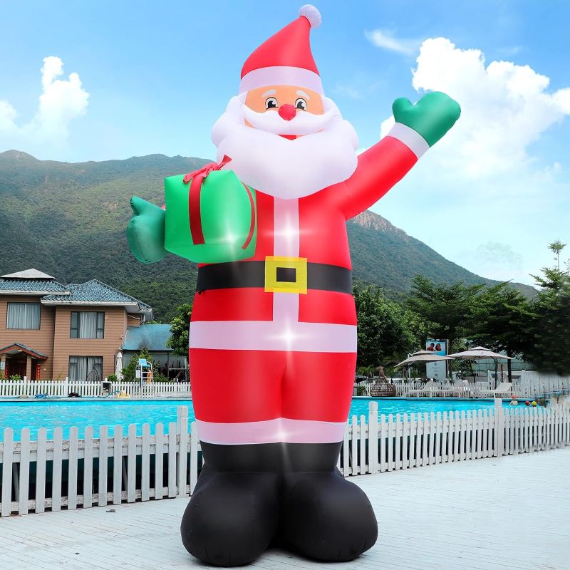 Photo 1 of 14 FT Giant Christmas Inflatable Santa Claus Outdoor Decorations, Blow up Santa Claus Holding Gift Box, LED Lighted Yard Decor for Patio Garden Lawn Hall Display Xmas Vacation Winter Holiday Party 