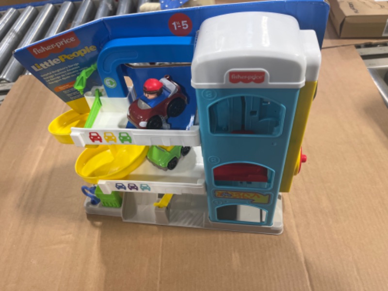 Photo 1 of Fisher-Price Little People Toddler Playset with Spiral Race Track, Elevator and 2 Wheelies Toy Cars, Helpful Neighbor’s Garage