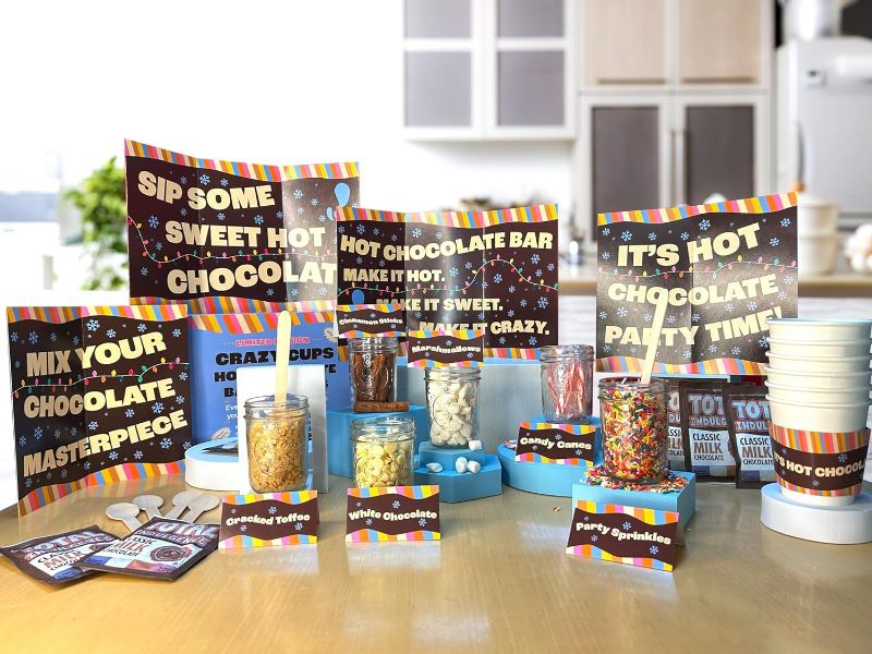 Photo 1 of Crazy Cups Deluxe Hot Cocoa Bar Supplies Kit, Includes Hot Cocoa Bar Signs, Marshmallows, Candy Canes, Cinnamon Sticks, Sprinkles, Hot Cups With Sleeves, Hot Chocolate, Table Tents, Spoons, 6 Servings Deluxe Hot Chocolate Bar Kit Pack of 1 BB 11/20/2024