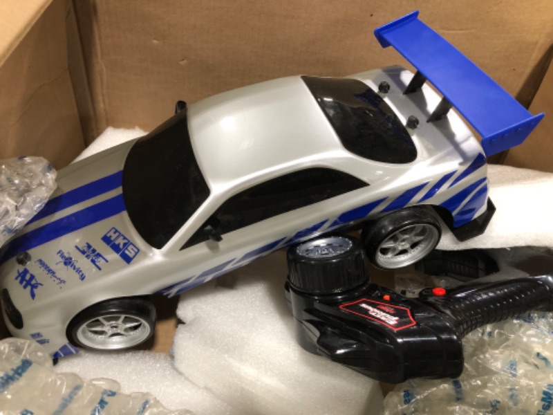 Photo 2 of Jada Toys Fast & Furious Brian's Nissan Skyline GT-R (BN34) Drift Power Slide RC Radio Remote Control Toy Race Car with Extra Tires, 1:10 Scale, Silver/Blue (99701)